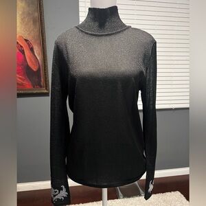 Black turtle neck cardigan with silver metallic. Appliqués on both wrist…
